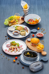 Dining still life. Dishes from chicken and turkey, mussels in saucepan and naked burger