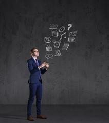 Businessman checking his smartphone on a dark dramatic background. Business, office, idea concept.