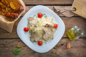 Salad with meat tomatoes and cheese on a plate