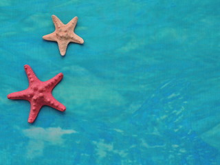 Fototapeta na wymiar Textiles turquoise sea background with starfish with blank space.