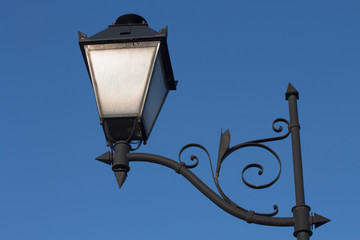 Fototapeta na wymiar One antique metal lantern against a blue morning sky