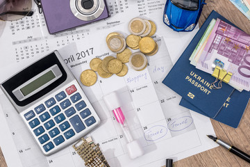 time to travel - passport, money, camera, watch, calculator, glasses, calendar toy car on wooden table.