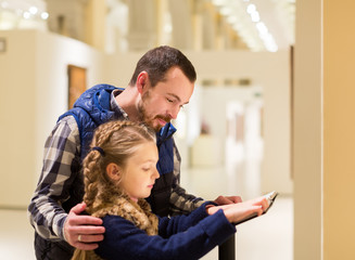 Young father and daughter looking at guide