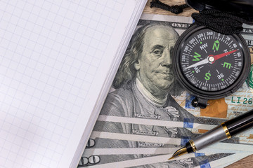 compass on usa hundred dollars with note, pen. journey concept.