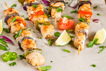 Fajita chicken kebabs, with chicken meat, pepper, chili, tomatoes, onions, lime juice and herbs. In a frying pan, on a rustic wooden table. Mexican cuisine, a traditional food,