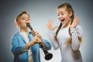 The boy plays the bassoon and the girl applauds