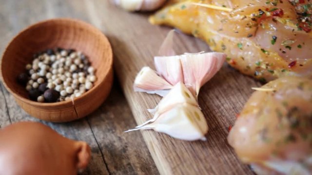 Spicy chicken breast with parsley and garlic on wooden board