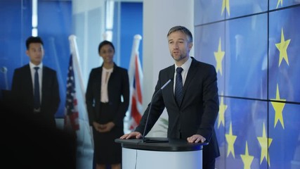  Politician making a speech at press conference, EU flag in background