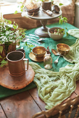 Vintage kitchen greenery decor with copper dish on wooden table