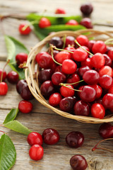 Ripe cherries in basket on a grey wooden table