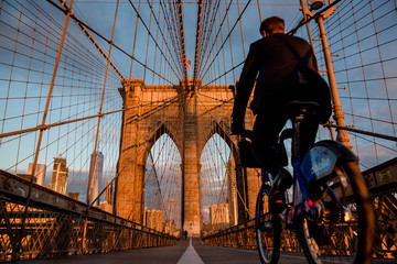 New York, Biker on the Brooklyn Bridge early morning heading towards Manhattan 