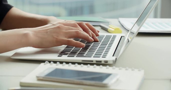 close-up of Asian business girl in a modern office, working using laptop