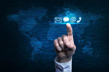 Hand pressing contact icon over world map.