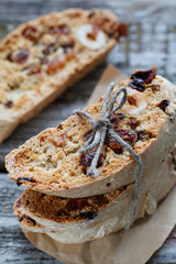 Close-up of tied Italian sweet homemade cookies biscotti with raisins and nuts on an old wooden...