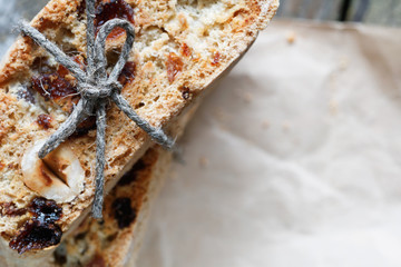 Top view of tied Italian sweet homemade cookies biscotti with raisins and nuts on an old wooden gray table. Place for text.