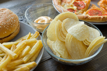 Unhealthy concept. unhealthy food: Burger, sauce, potatoes, donuts, pizza, drink.