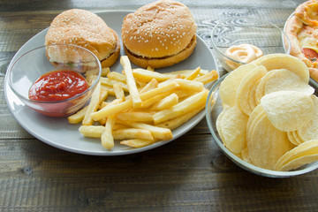 Unhealthy concept. unhealthy food: Burger, sauce, potatoes, pizza. Close up.