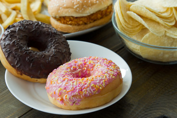 Unhealthy concept. unhealthy food: Burger, sauce, potatoes, donuts.