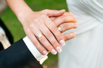 Obraz na płótnie Canvas Hands of newlyweds with wedding rings.