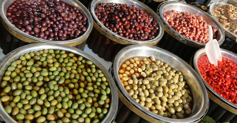 Italian market stall with olives and red peppers for sale
