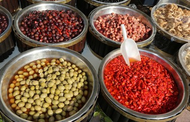 Mediterranean market stall with big olives and red peppers