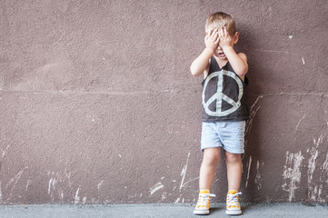 Child boy corner face with hands