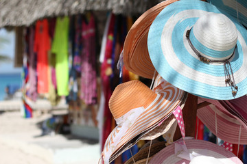 Sale of hats and clothes in a beach market at the Catalina Island in Dominican Republic - obrazy, fototapety, plakaty