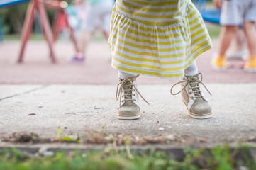 Little caucasian girl sitting in stroller and gives hands to her mother