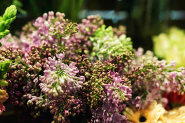 Obraz premium Lilac bouquet,Colorful roses and other flowers at the entry to flower shop,Bouquet decorate in front of flower shop,Many flowers in the market,flowers at farmers' market