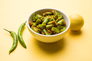 closeup picture of  Homemade hari mirch ka achar or green chilli pickle in a white bowl, selective focus