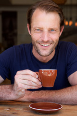 handsome man drinking coffee and smiling