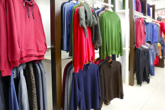 Racks with different clothes in modern shop