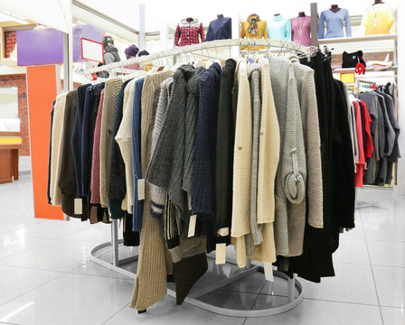 Rack with different clothes in modern shop