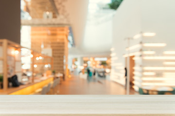 Wooden board empty table top on of blurred background. Perspective brown wood table over blur in coffee shop background - can be used mock up for montage products display or design key visual layout.