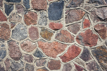 Mosaic rough wall made with rocky stones background.