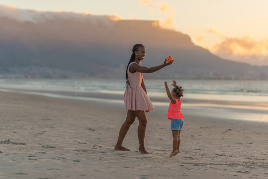 Mother playing with her daughter at the beach