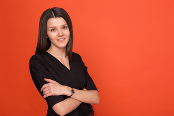 Obraz premium Beautiful young girl in a business suit on a red background