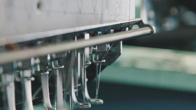 Embroidery needle, Needle with thread. Embroidery machine on T-shirt in Textile Industry at Garment Manufacturers. Machine embroidery is an embroidery process whereby a sewing machine.