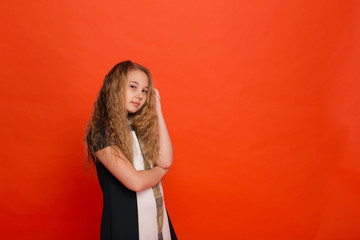 Girl in beautiful stylized dress on a red background in the studio