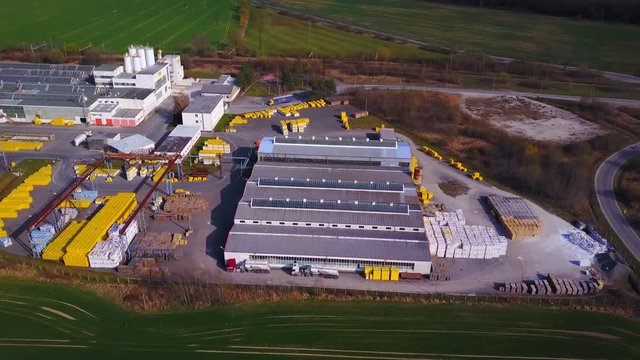 Aerial view of industrial area. Camera flight over factory plant producing autoclaved aerated concrete.
