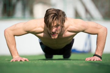 Fototapeta na wymiar muscular man doing push ups, male athlete exercising push up