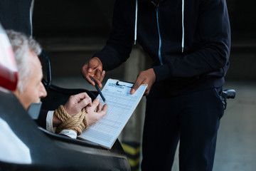 Unhappy senior man being forced to sign the document