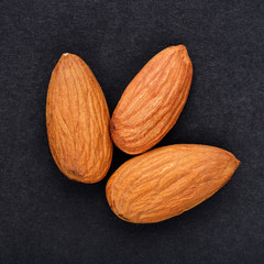 almonds nuts close up on black slate background top view