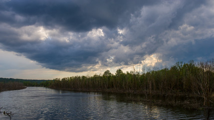 Landscape river and forest before rain in the evening