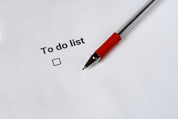 To do list with red pen on white paper