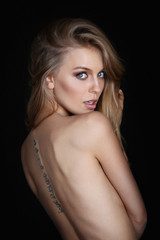 Fototapeta premium Woman with tattoo on her back
