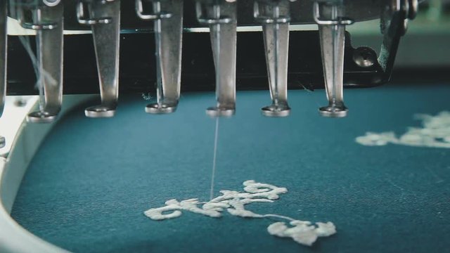 Industrial embroidery equipment. Machine embroidery work. Machine embroidery is an embroidery process whereby a sewing machine. Textile - Professional and industrial embroidery machine.