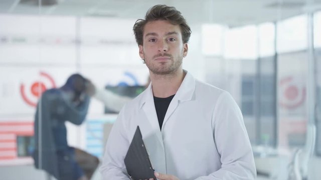  Portrait of sport scientist in white coat, man on exercise bike being tested in background. 