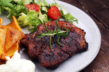 Grilled steaks, baked potatoes and salad