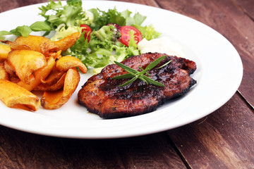 Grilled steaks, baked potatoes and salad